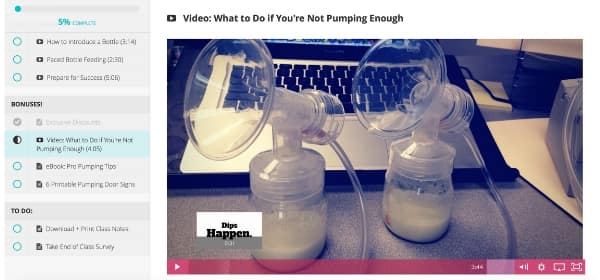 a screenshot of the courses video lesson modules, pictured: two bottles of pumped breast milk sitting on a desk in front of a laptop.