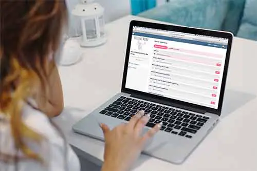 Woman taking an online pumping course on a MacBook laptop.