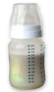 Black colored breast milk inside of a baby bottle.