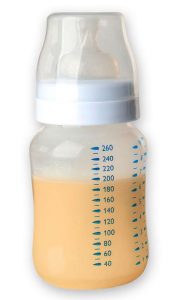 Orange colored breast milk in a baby bottle.